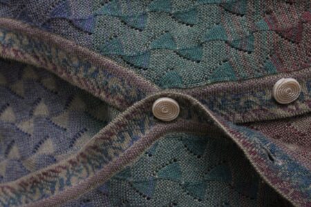 Eton College Rowing Blade Chevrons Are Quietly Striping Into Knitwear Panels Close-up of a knitted sweater panel showing bold diagonal chevron stripes in navy and gold