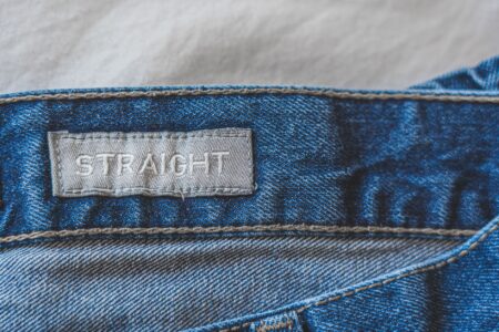 Eton College Field Game Knicker Buckles Are Quietly Clasping Into Trouser Tabs Close-up of metal buckle hardware on a tailored trouser leg, showing functional side-cinching detail