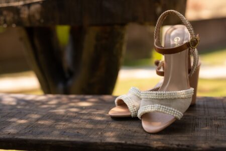 Close-up of a narrow leather strap with a small roller buckle worn around a bare ankle