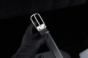 Close-up of flat metal buckle hardware on a thick leather belt strap