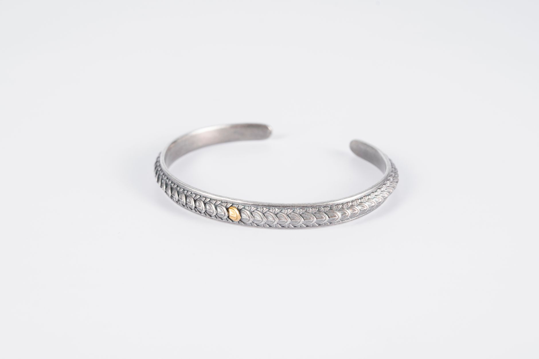 Minimalist metal wrist cuff resting on a neutral surface
