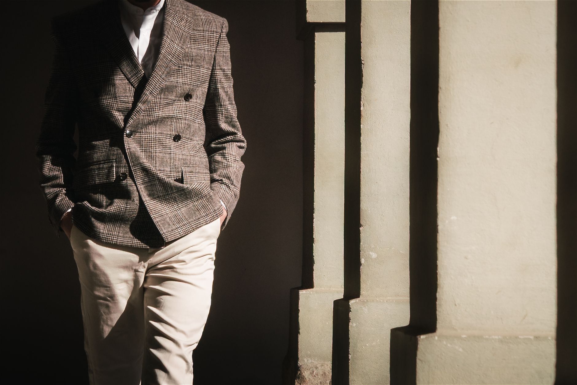 A formal men's jacket laid flat showing sleeve cuff hardware and refined button detailing