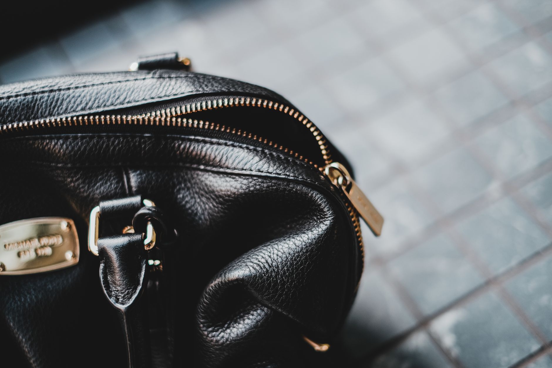 Detail shot of a leather bag gusset showing mounted D-ring attachment point